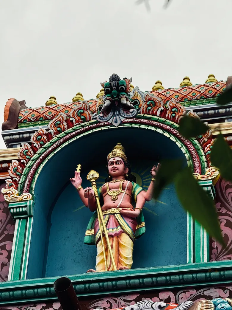 Painted temple deity under an arched niche