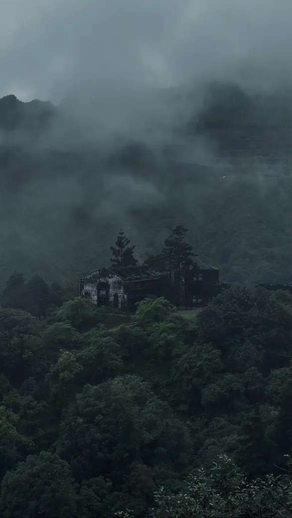 Old building in misty forested hills